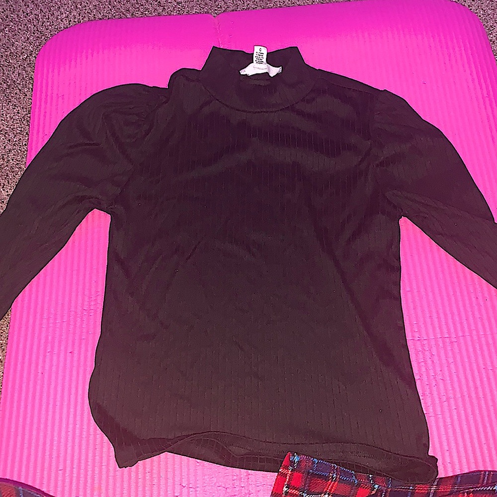 A black, turtle ish neck, long sleeved with Puffed shoulders